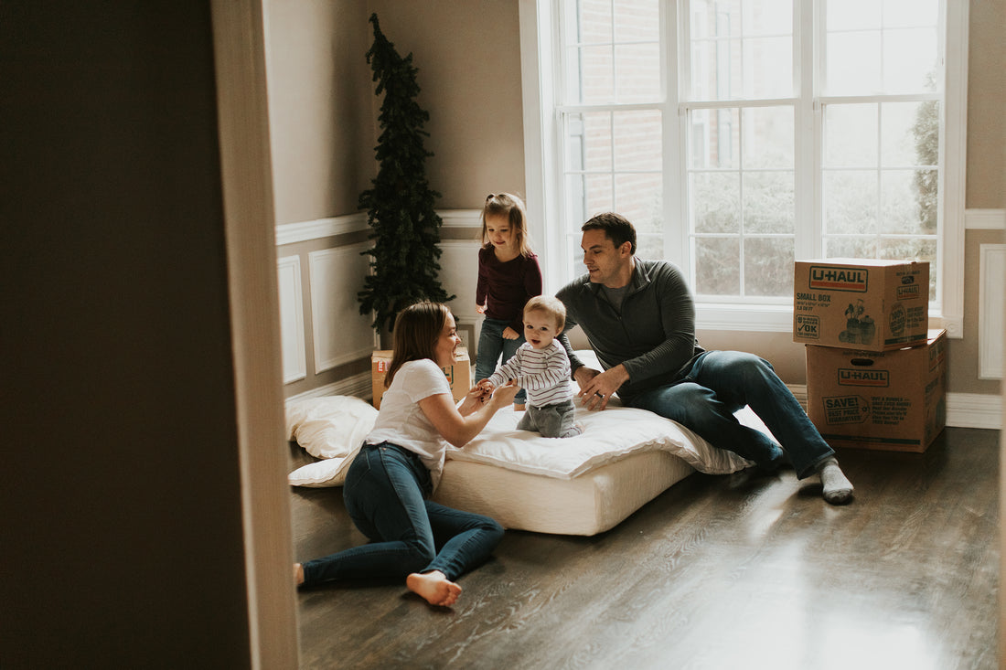 KaleidaCuts Family playing with children, sitting in new house surrounded by moving boxes.
